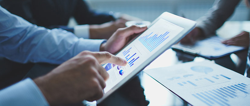 Close up shot of business professional reviewing statistics on a tablet.
