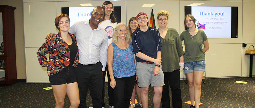 A group of students, staff and faculty pose in front after an alphabet soup event.