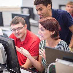 Three students working together at a computer. 