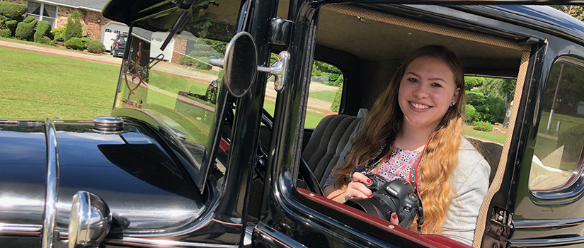 Rebecca Dymock in an antique automobile