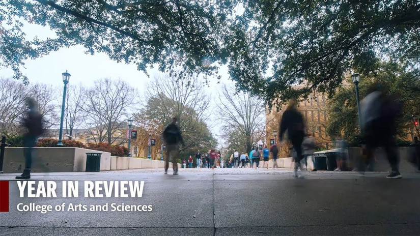 students walking over a bridge and image reads "year in review" College of Arts and Sciences