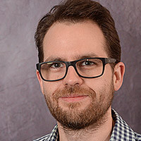 photo of man in blue shirt with glasses