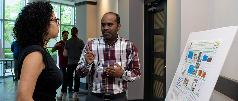 two people discuss a research poster