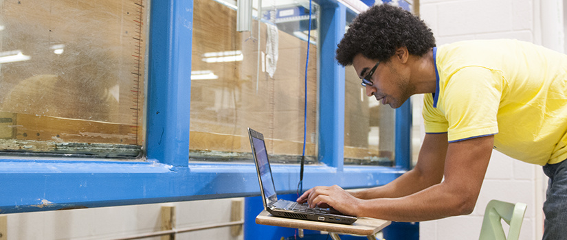 a male student works on a laptop