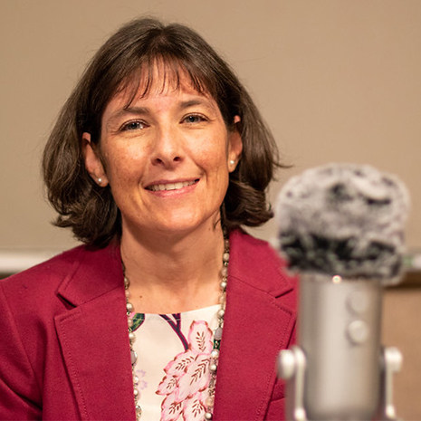 Nicole Berge sits behind a microphone