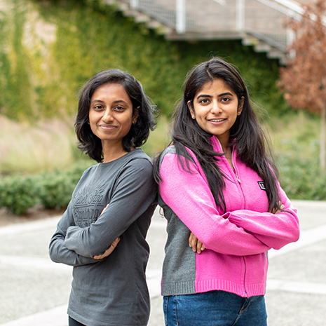 Two AI students in courtyard.