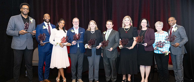 Winners of the HRSM Alumni Awards display their awards.