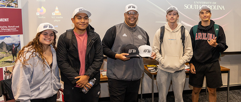 Students pose with a guest speaker for a panel discussion on the 50th anniversary of hip hop