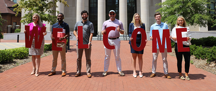 Students with WELCOME sign in front of USC School of Law building