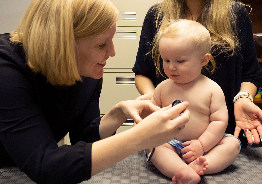 Researcher listening to a baby's heart.