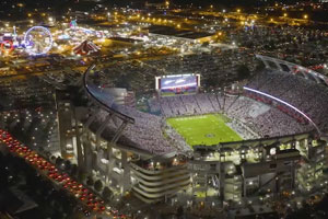 Williams Brice Stadium at night with the city lights behind it. 