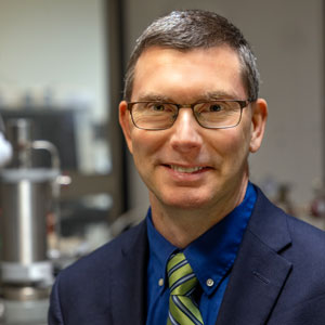 man stands in front of lab equipment